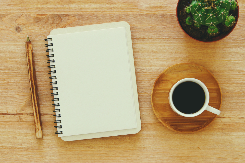 Journal vierge avec un stylo à côté d'une tasse à café