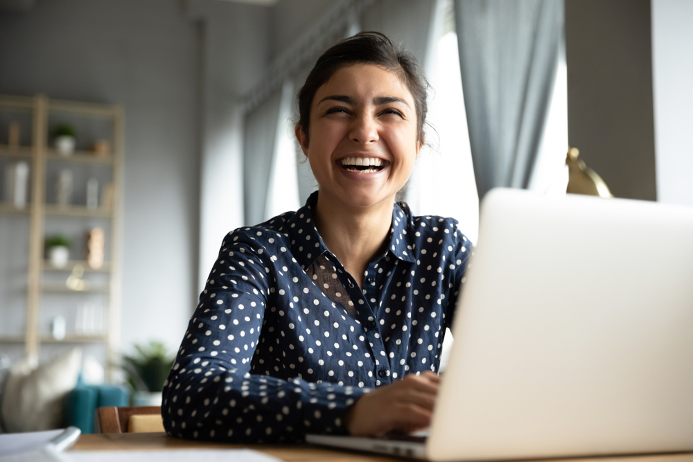 Woman on her computer who is laughing