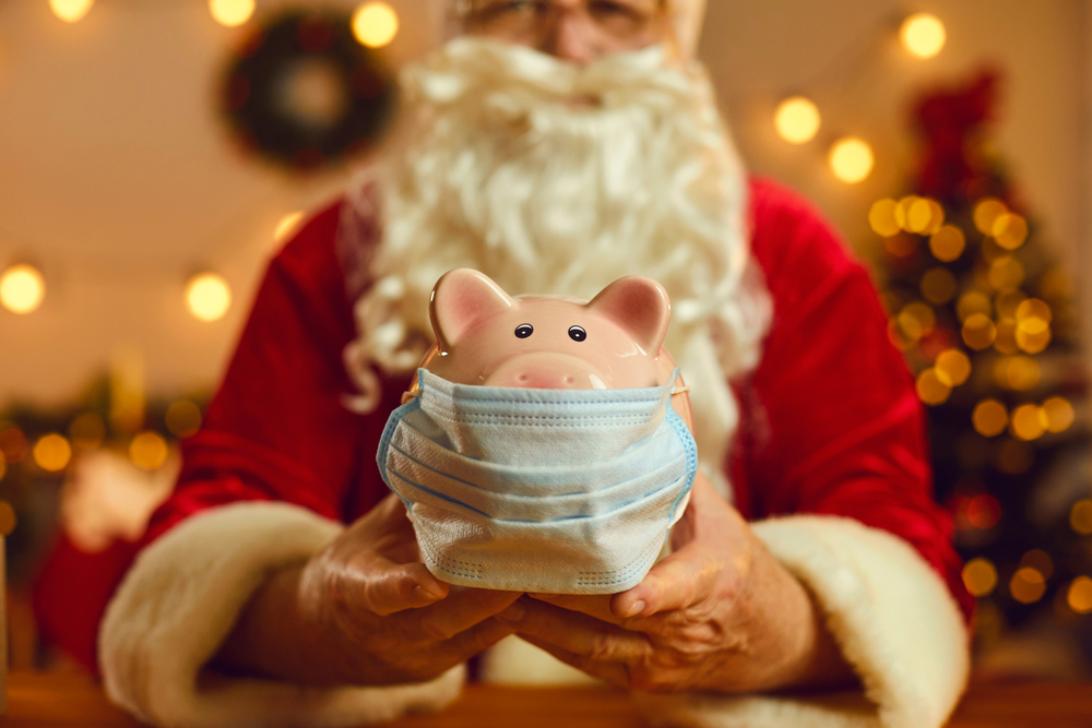 Santa holding a piggy bank with a mask
