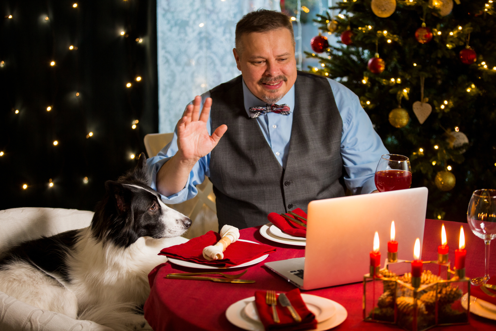Man eating dinner remotely with his family using videoconferencing
