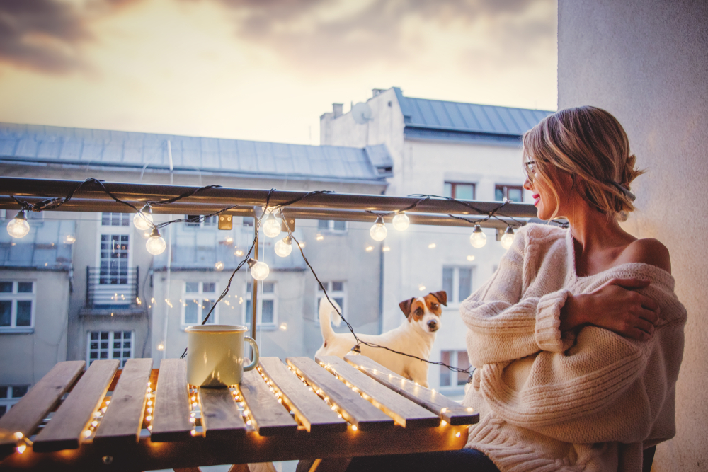 Woman sitting on her balcony with patio lights