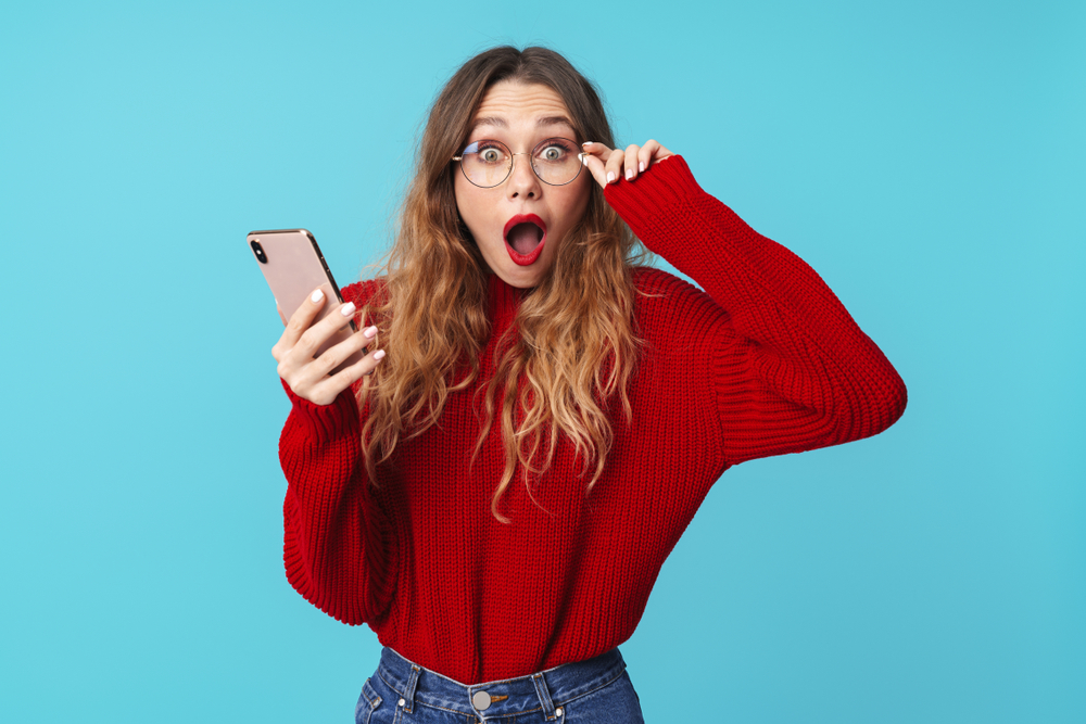 Femme surprise regardant son téléphone intelligent
