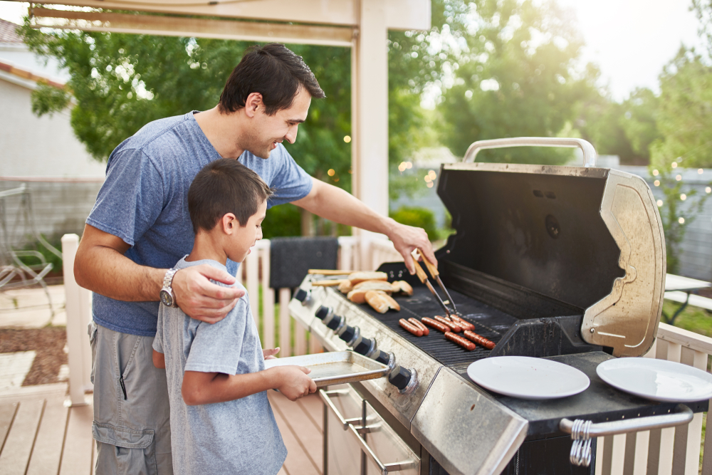 Un homme sert de la nourriture à son fils lors d'un barbecue dans leur cour arrière