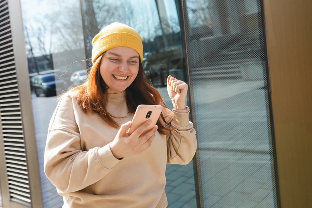 Woman celebrating winning a contest on her smartphone