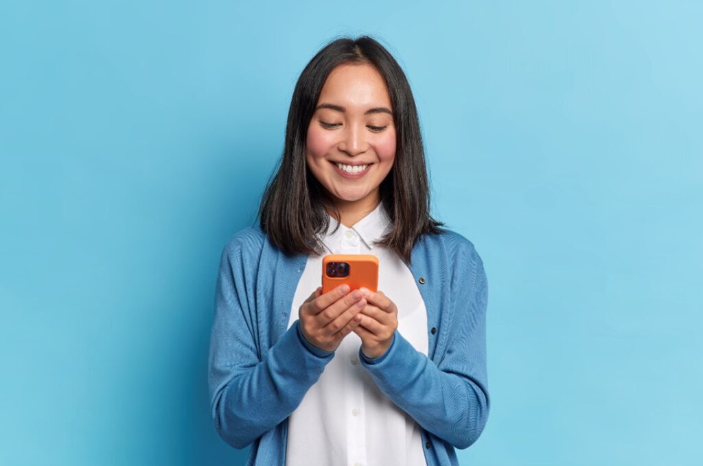 femme souriant à son téléphone