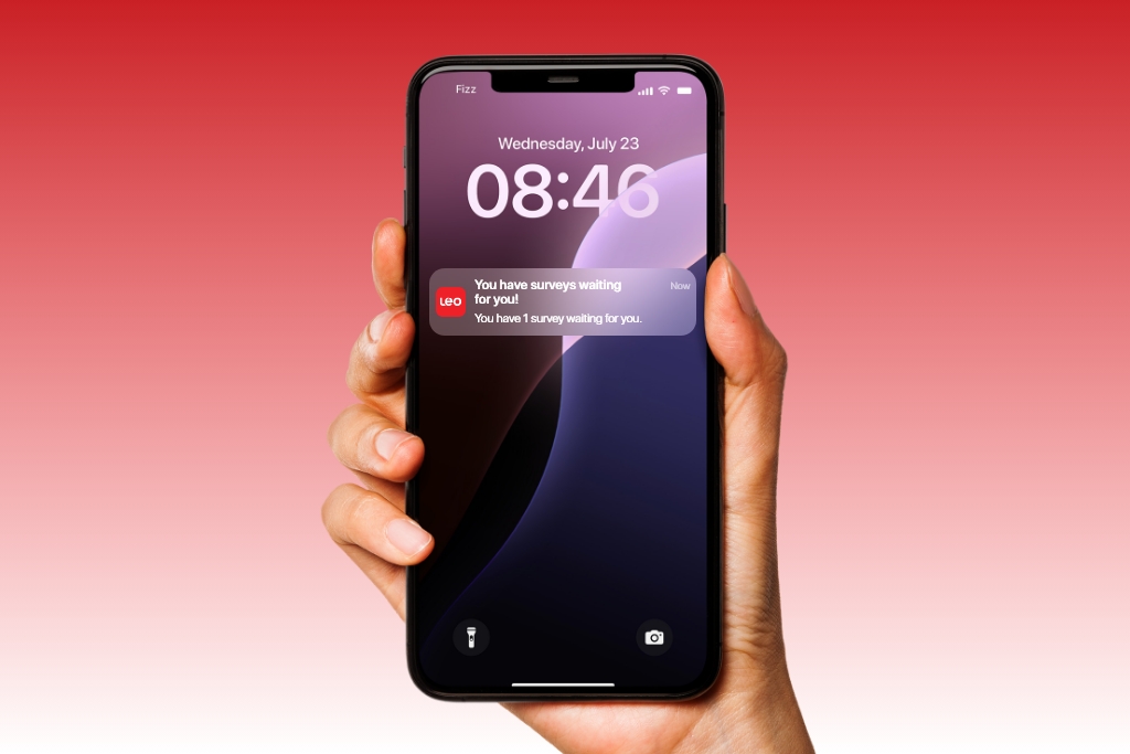 Hand holding a smartphone showing a Léger Opinion (LEO) paid survey notification — Canada’s leading survey platform. The device is centered on a blurred background, representing the moment a mobile survey alert is received.