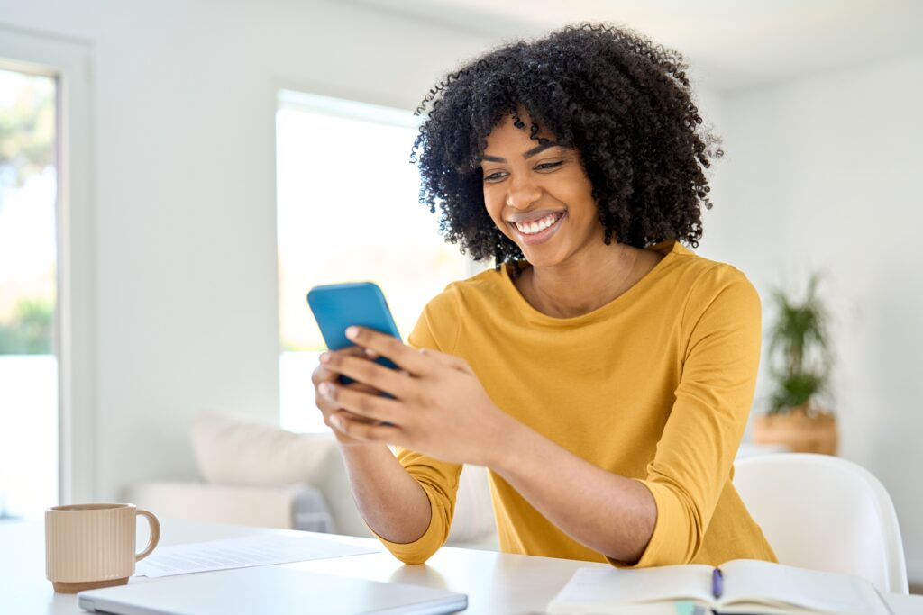 Happy young woman, smiling while using the LEO platform on her smartphone for an intuitive digital experience.